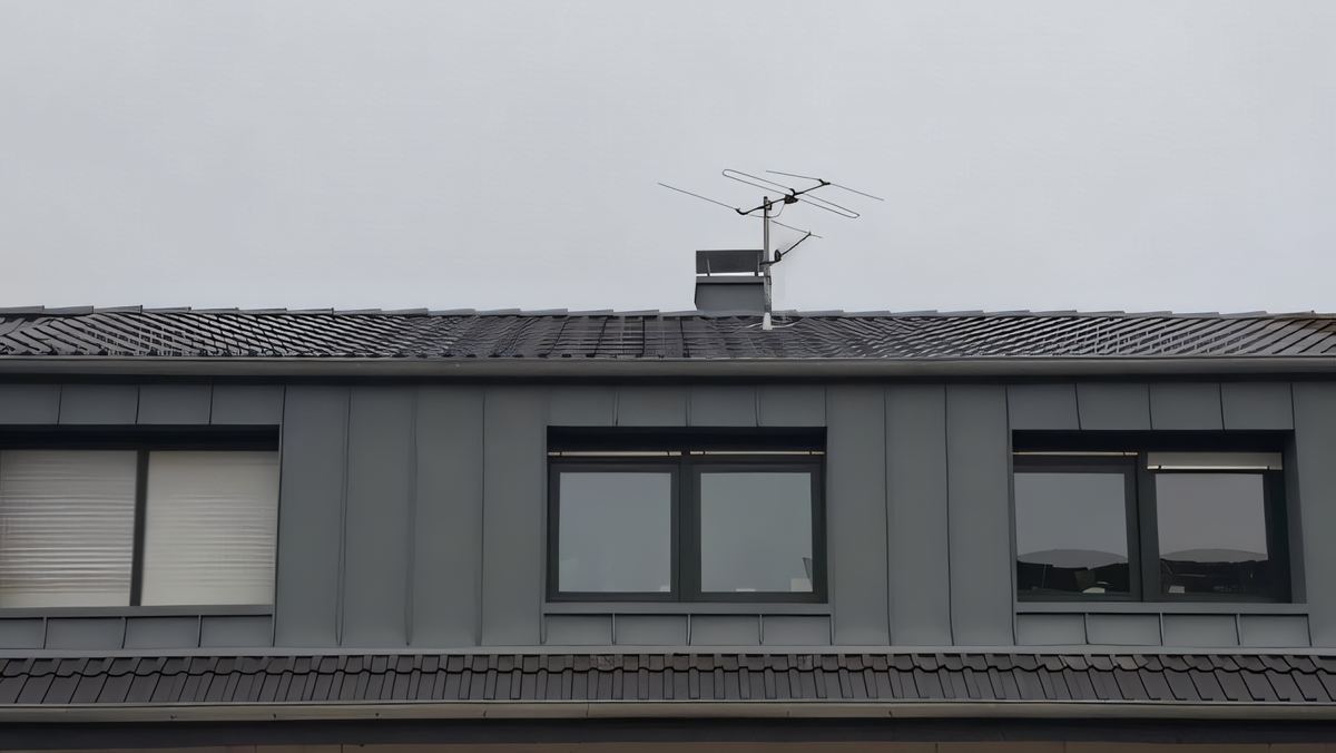 Dieselbe Gaube mit grauer senkrechter Metall-Stehfalzbekleidung und neuen dunklen Fenstern