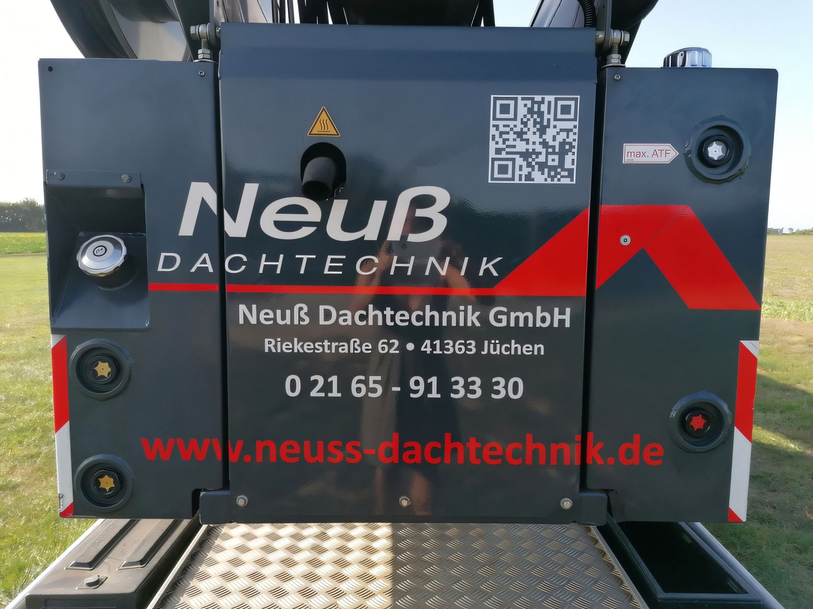 Heck des Anhängerkrans mit Neuß-Logo, Firmenname, Adresse Riekestraße 62, Telefonnummer und Webadresse